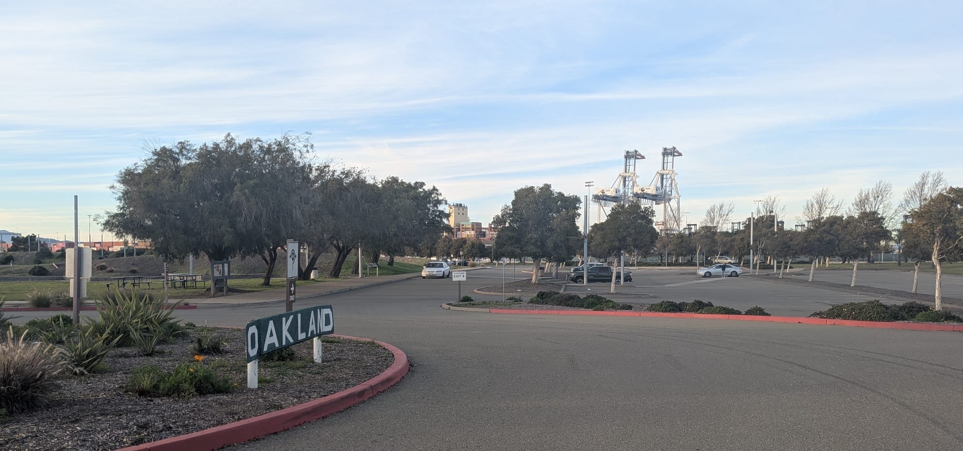 An Oakland sign, with the gantry cranes looming in the distance.