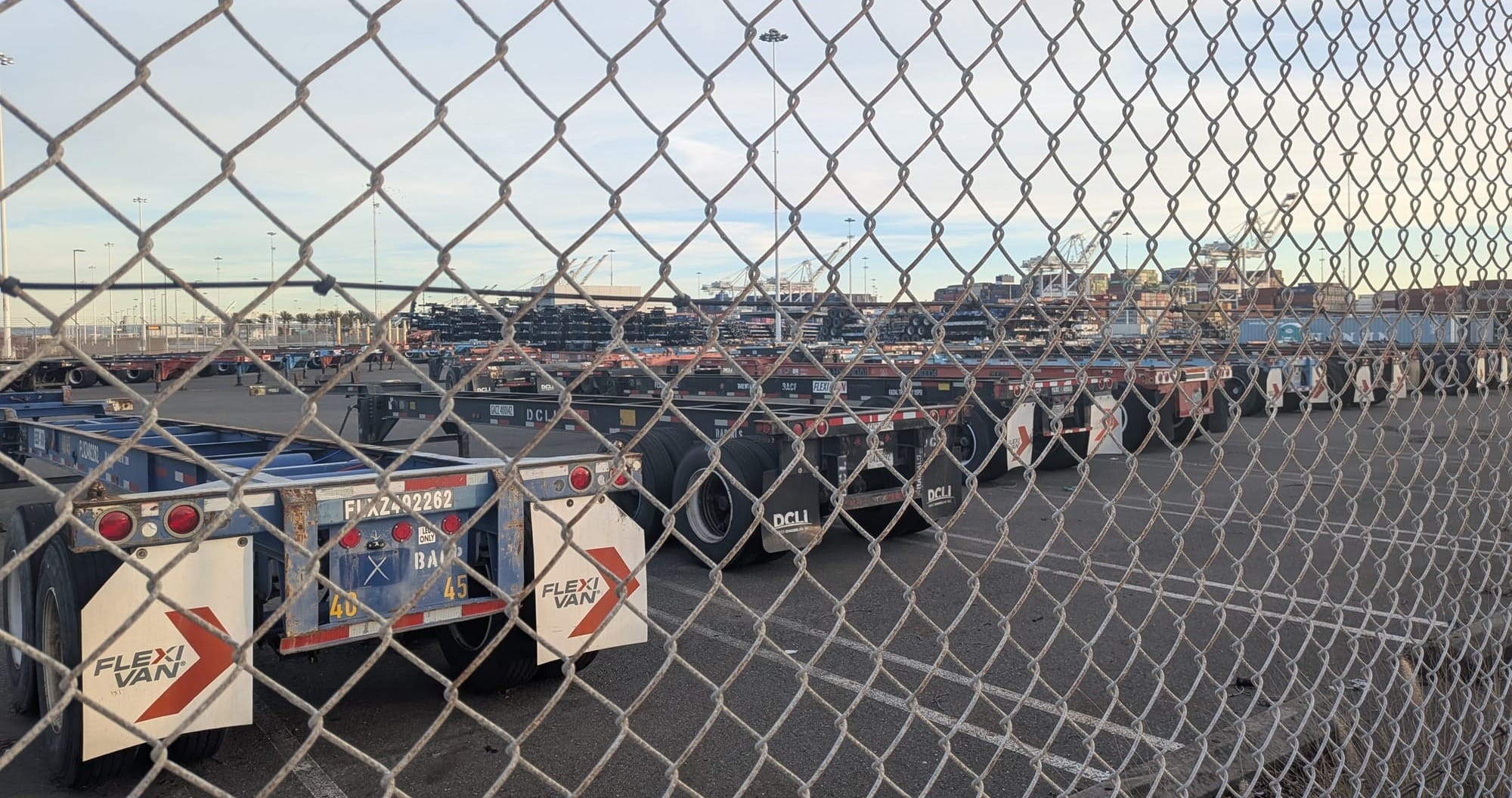 Truck  and gantry cranes behind a fence.