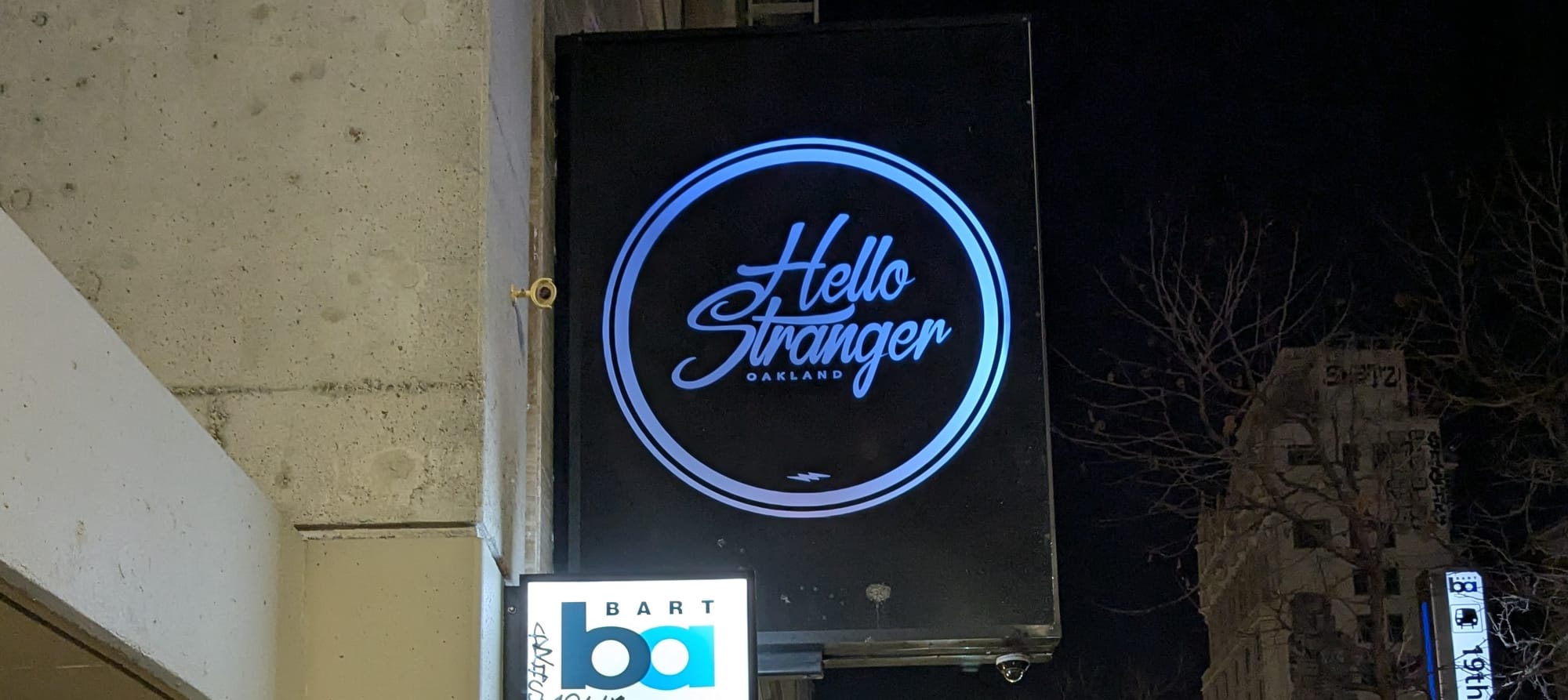 Photo of a bar sign reading "Hello Stranger"